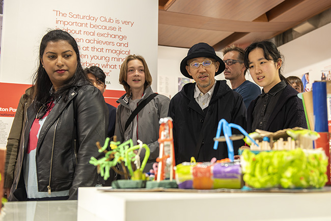 Visitors taking in artworks made by young people for the National Saturday Club Summer Show in 2022 at Somerset House