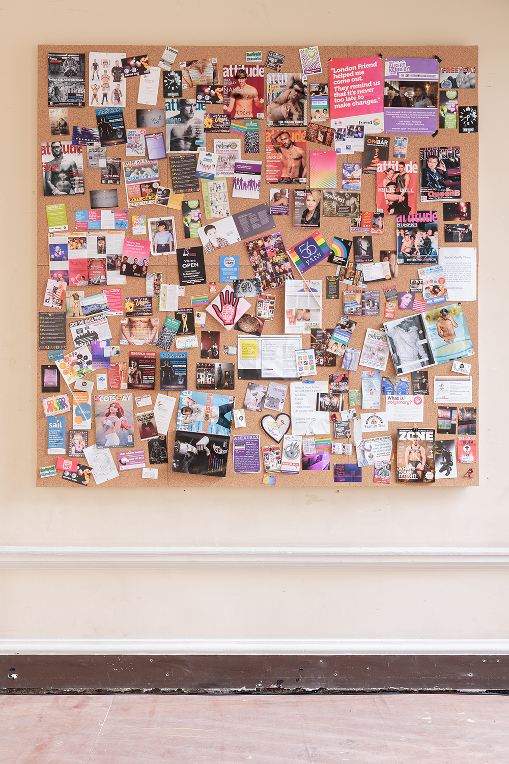 Installation view of UK Gay Bar Directory. The image shows an artwork presenting flyers and flags from different gay bars.